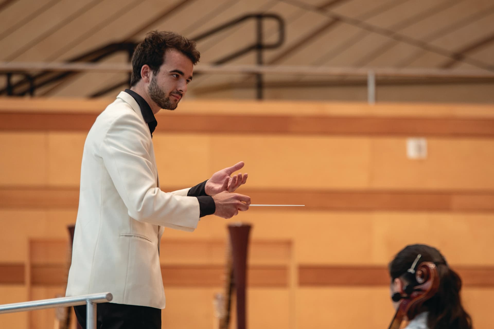 A man in a white jacket holding a stick