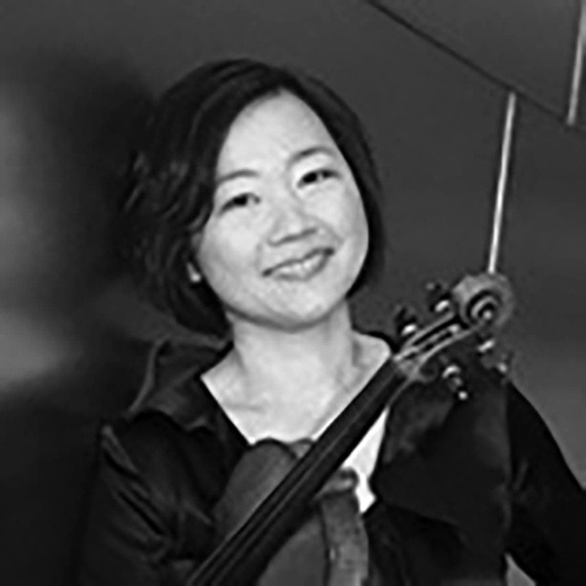 A woman holding a violin in her right hand