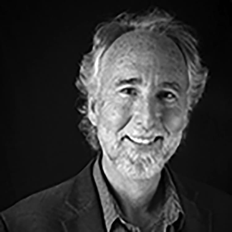 A black and white photo of a man smiling