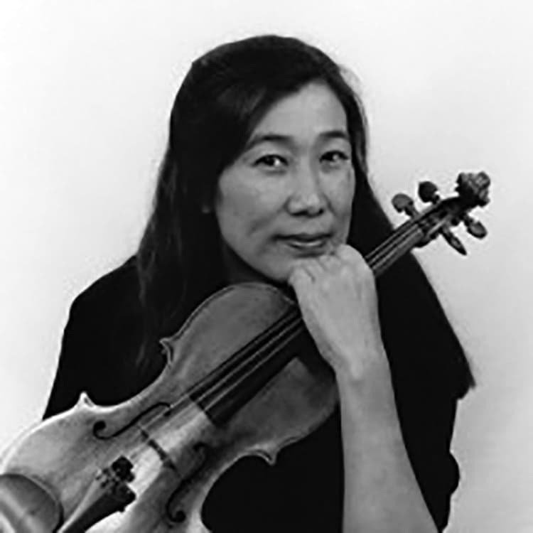 A woman holding a violin in her right hand