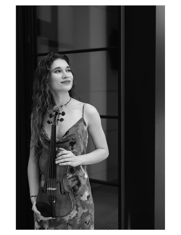 A woman in a dress holding a violin