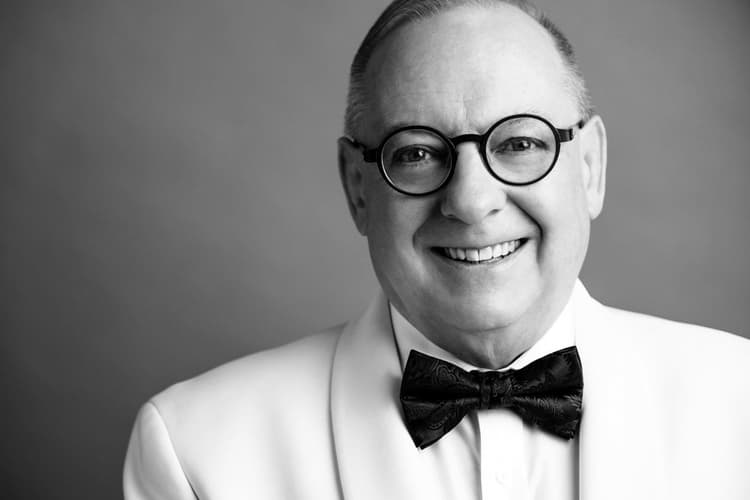A black and white photo of a man in a tuxedo