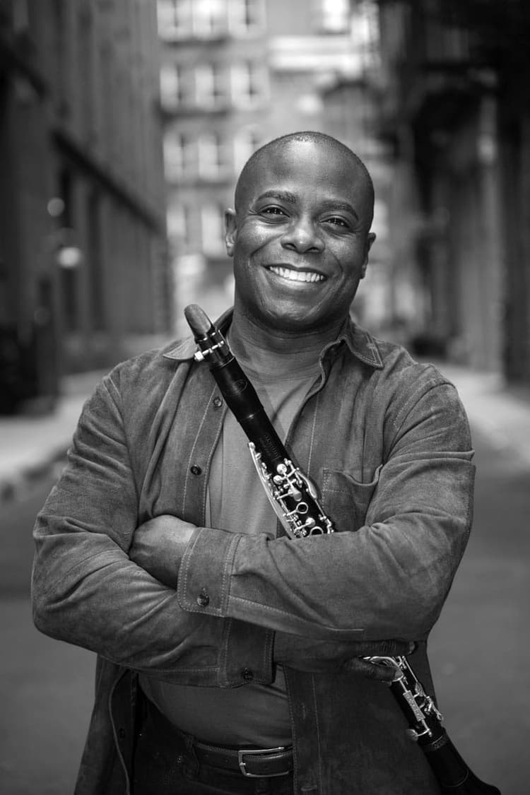 A black and white photo of a man with a saxophone