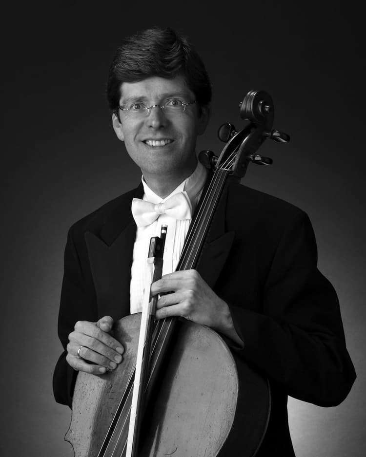 A man in a tuxedo holding a violin