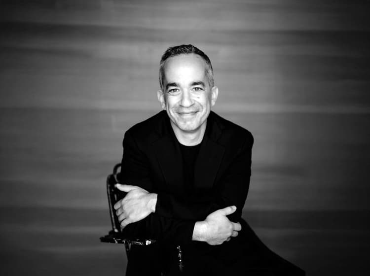 A black and white photo of a smiling man