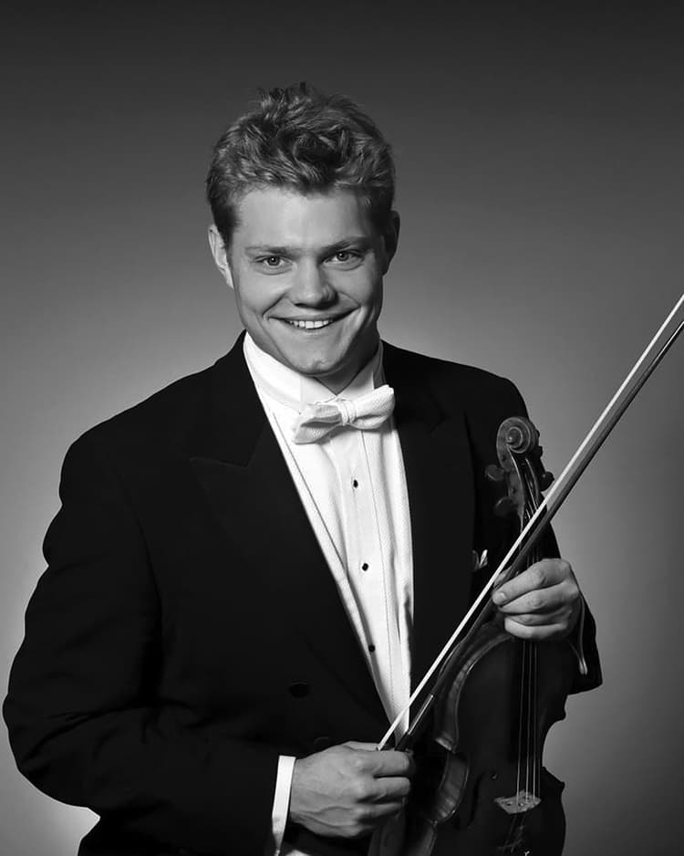 A man in a tuxedo holding a violin