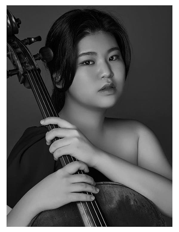 A woman holding a cello in her hands
