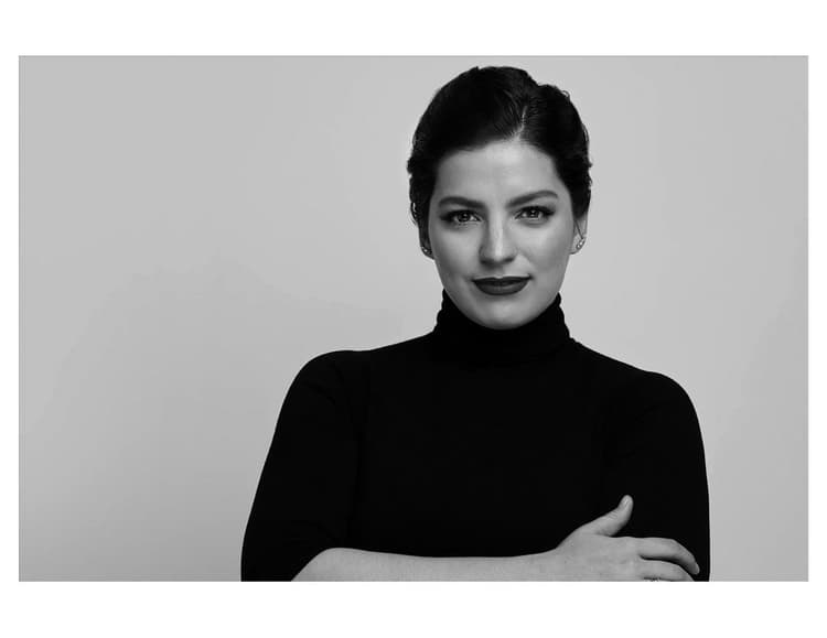 A black and white photo of a woman with her arms crossed