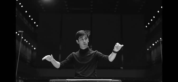 A man sitting at a table with his hands in the air
