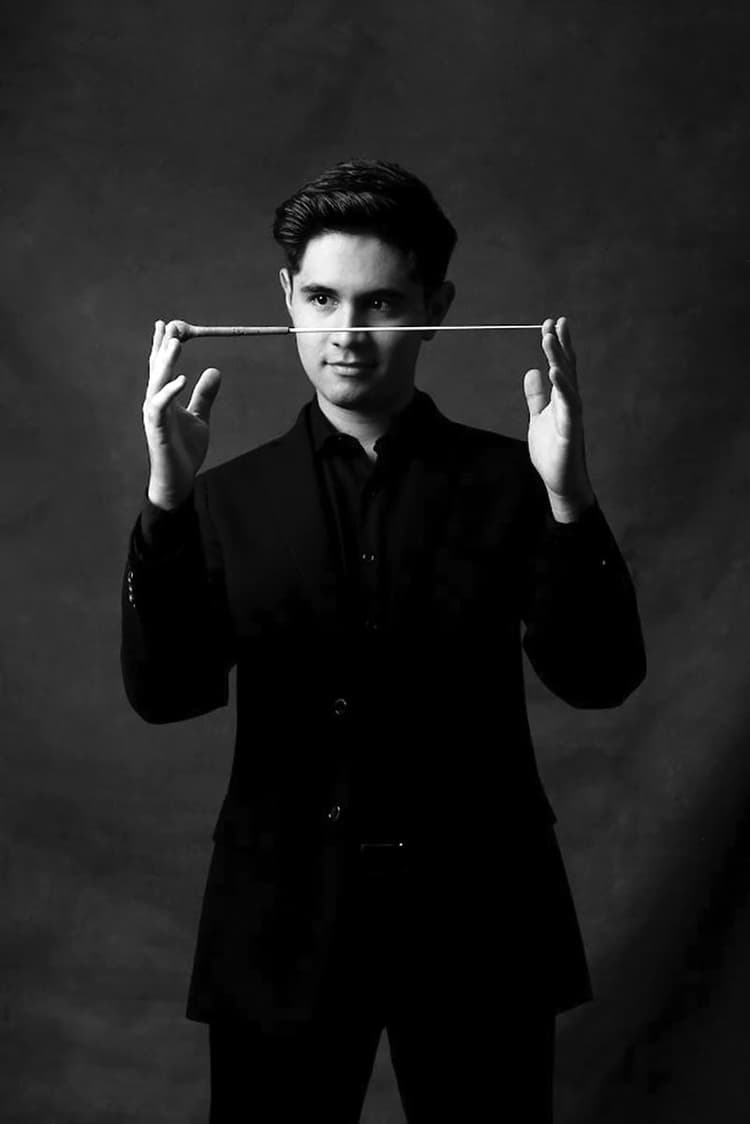 A man in a suit holding a stick above his head