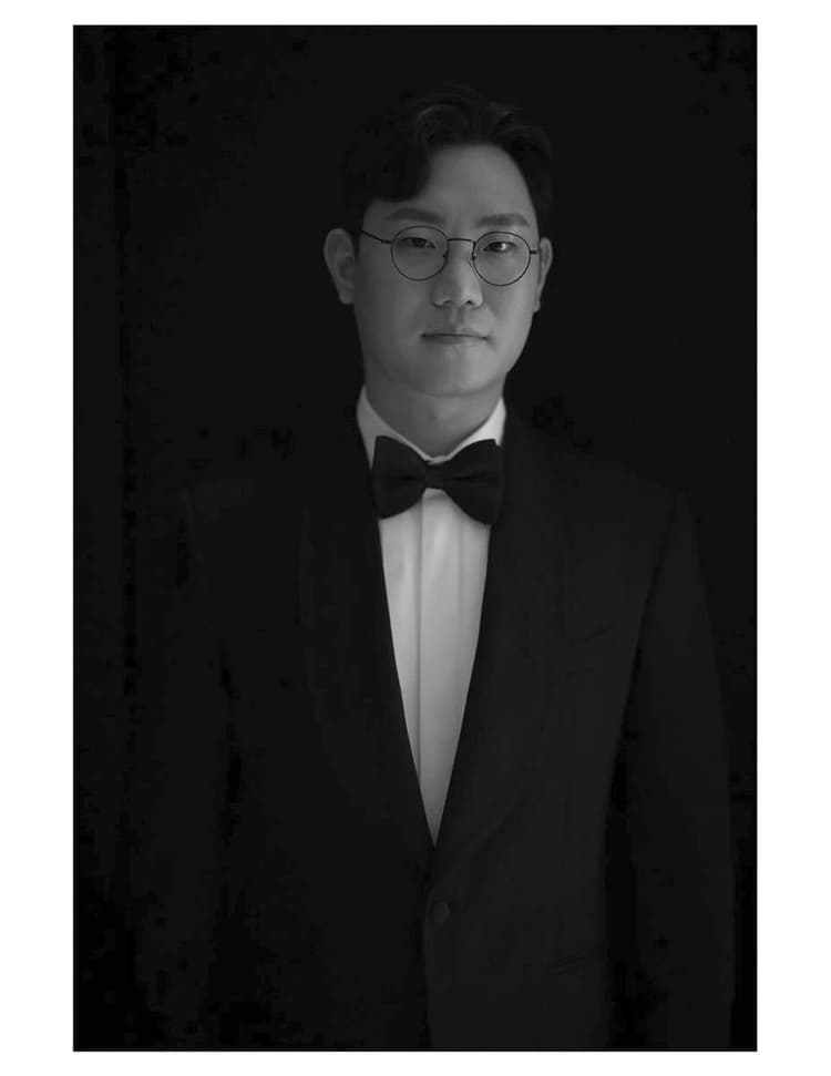 A black and white photo of a man in a tuxedo