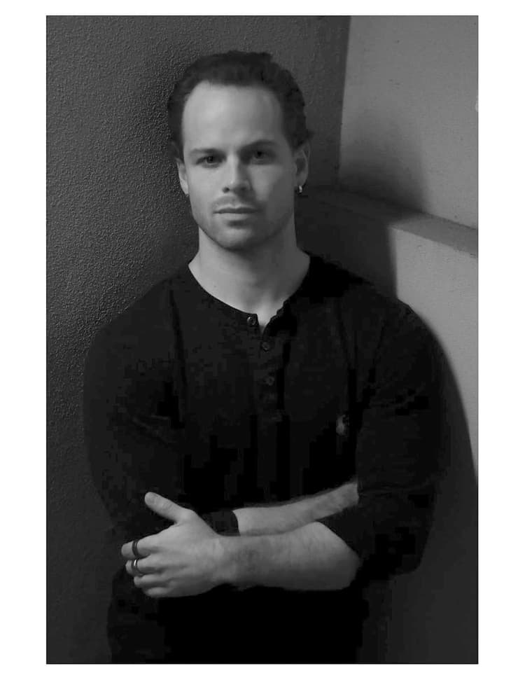 A black and white photo of a man with his arms crossed