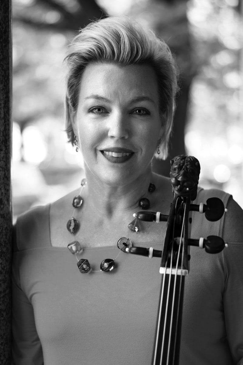 A woman in a dress holding a violin
