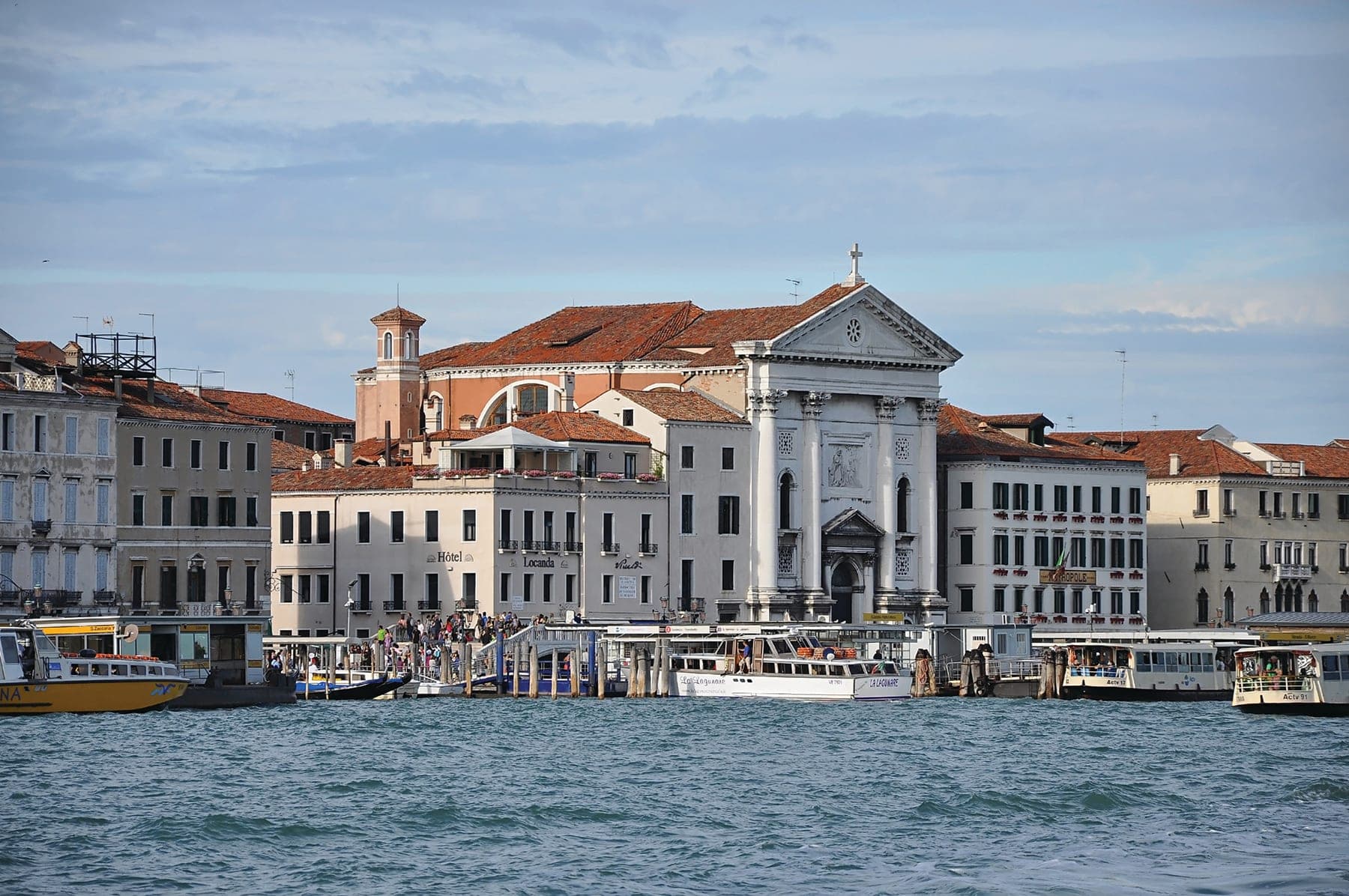 A large white building sitting next to a body of water
