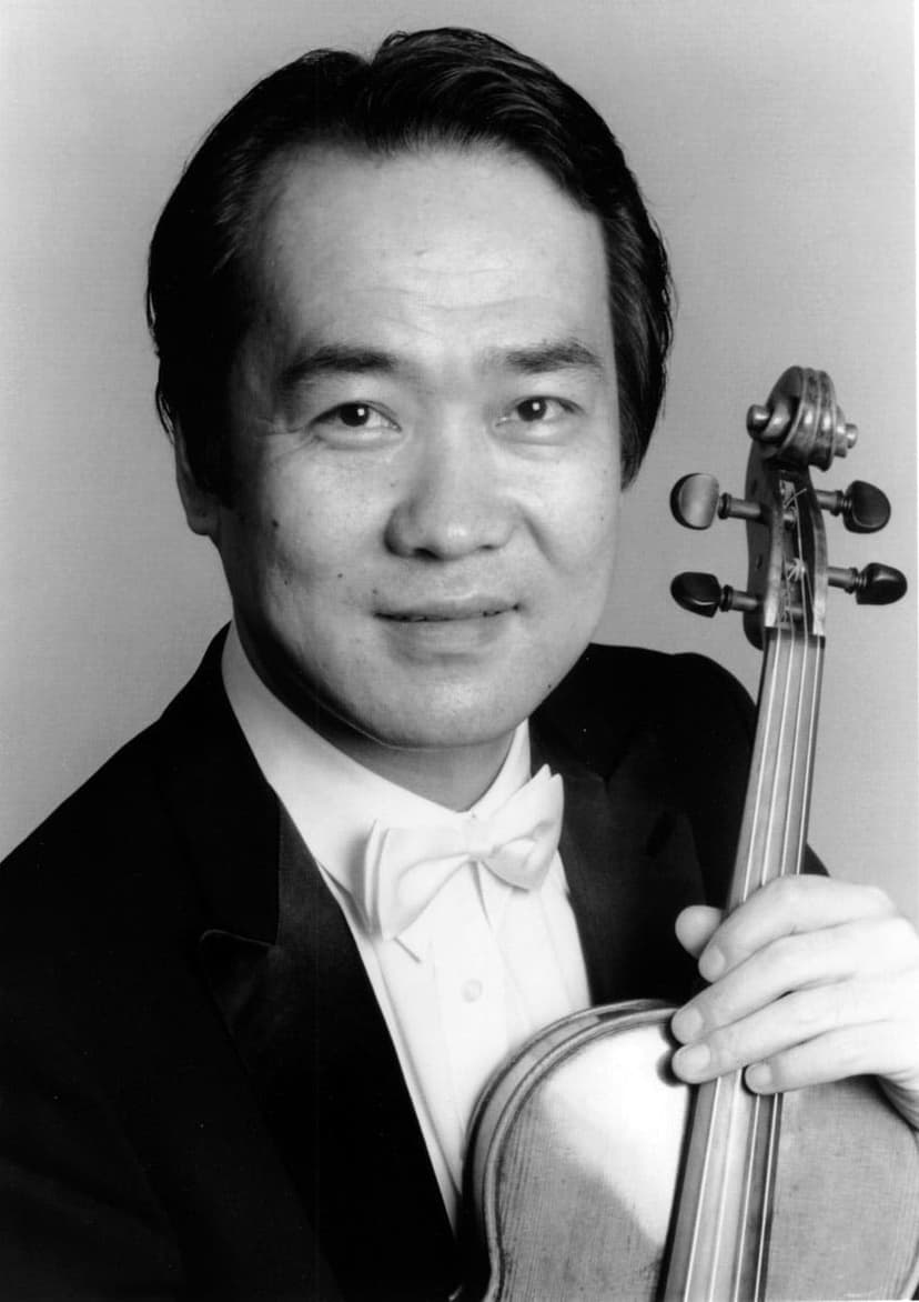 A man in a tuxedo holding a violin