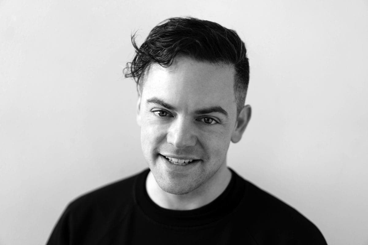 A black and white photo of a man smiling