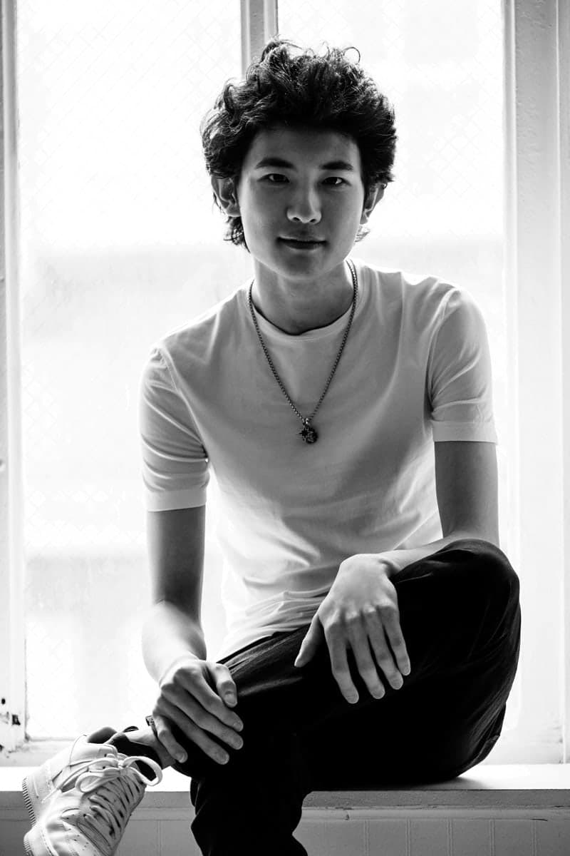 A young man is sitting on a window sill