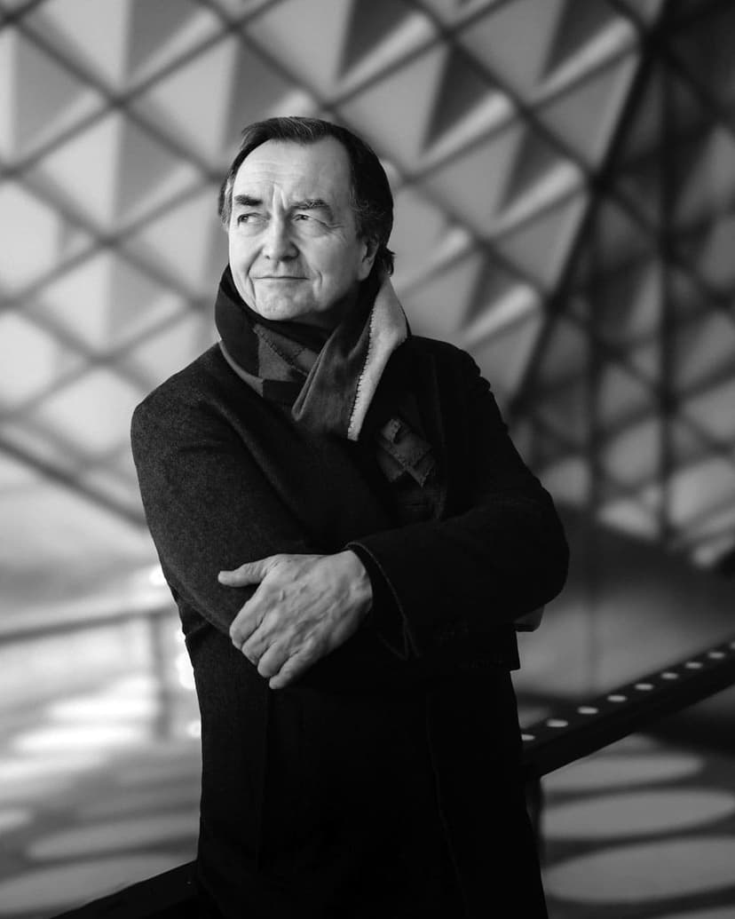 A black and white photo of a man with his arms crossed