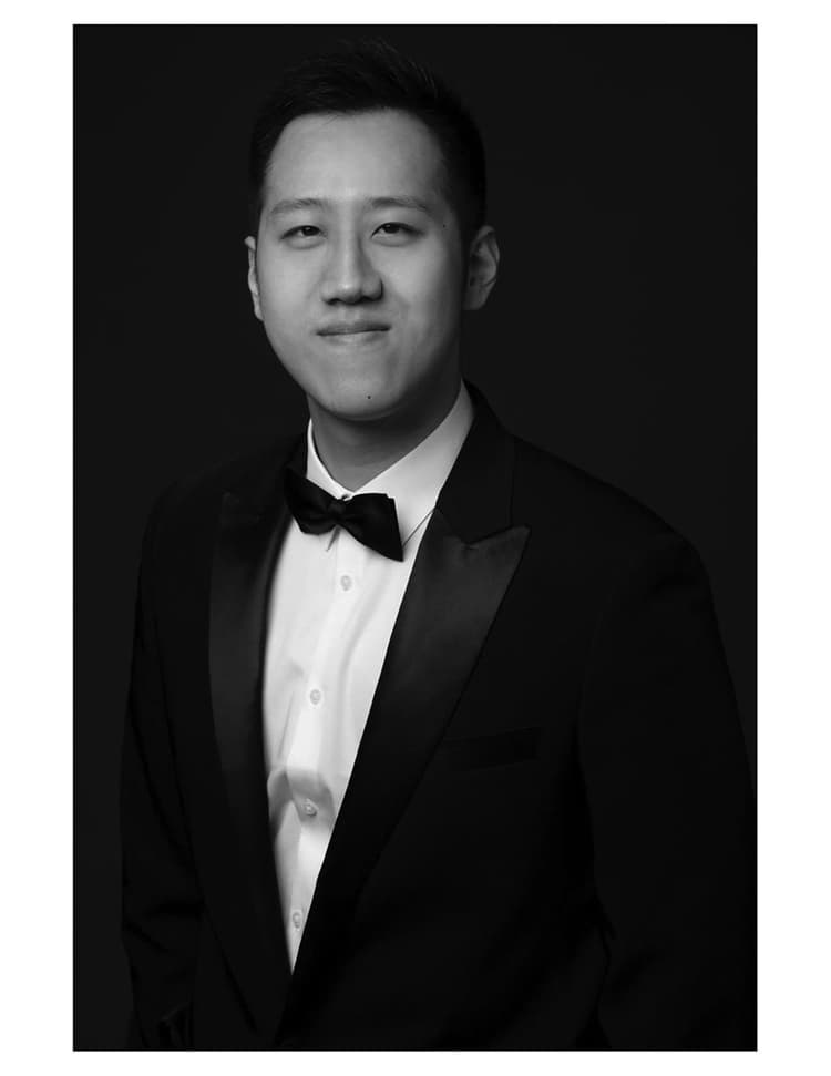 A black and white photo of a man in a tuxedo