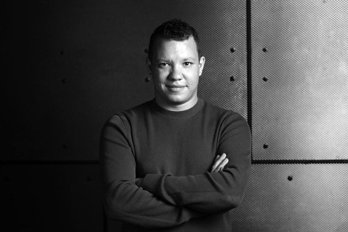 A black and white photo of a man with his arms crossed
