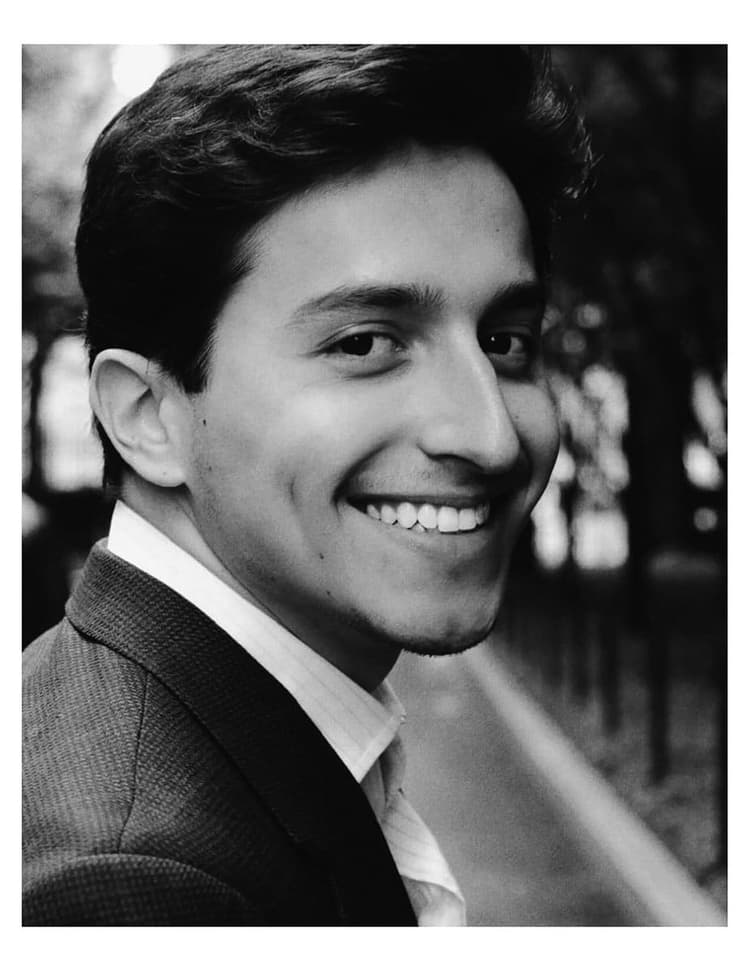A black and white photo of a smiling man
