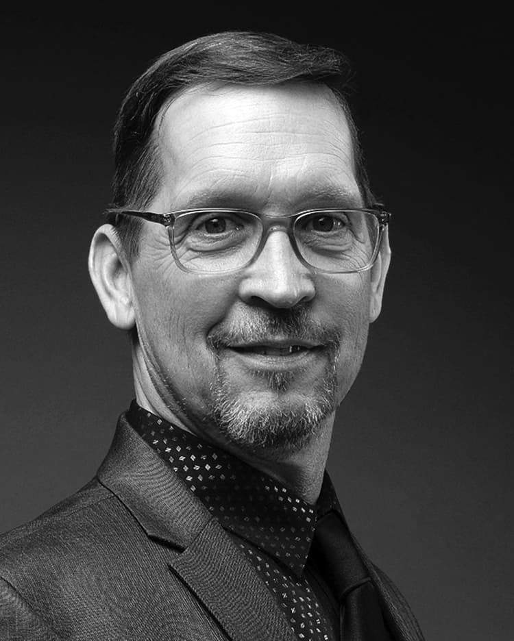 A black and white photo of a man wearing glasses