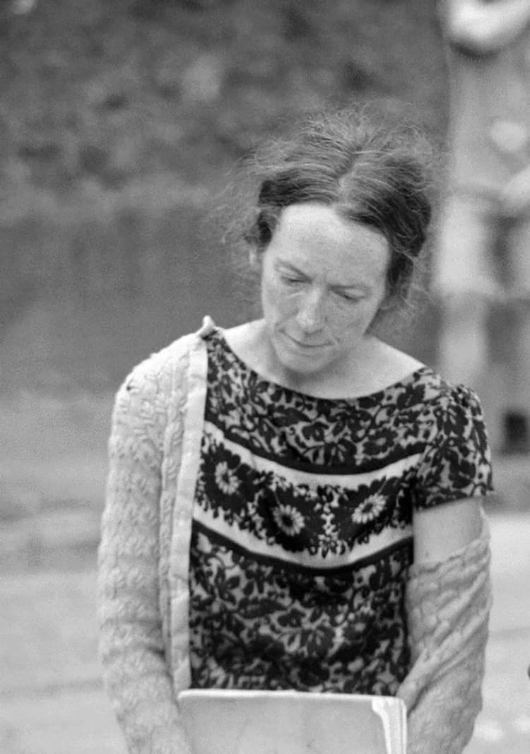 A black and white photo of a woman holding a book
