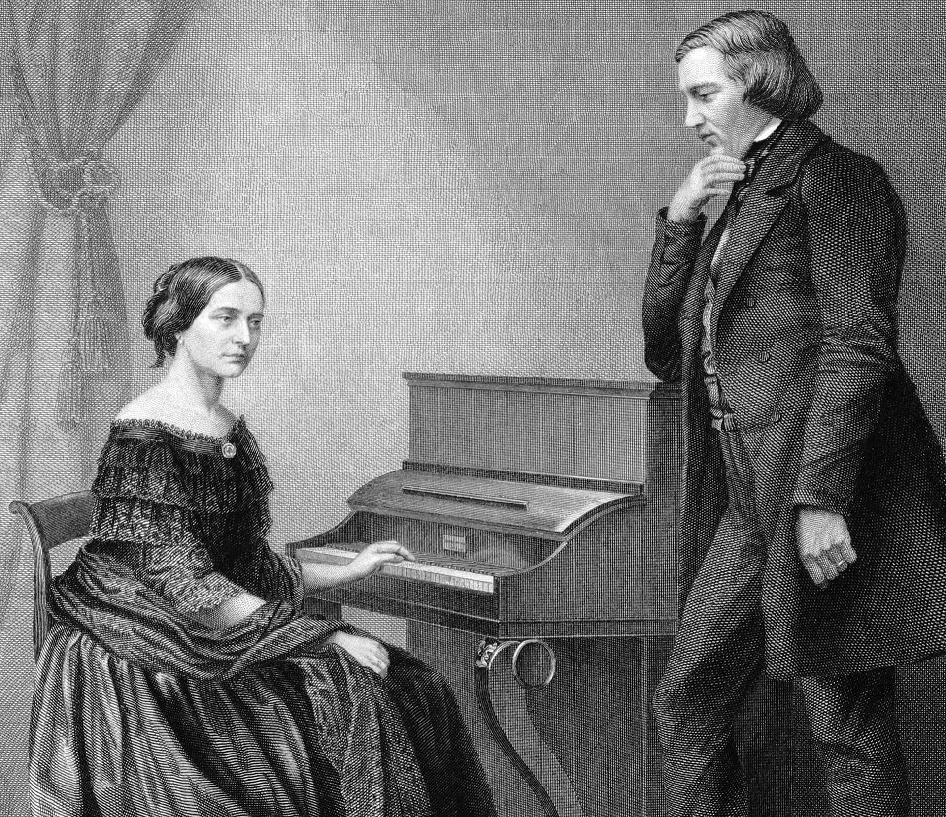 A man standing next to a woman in front of a piano