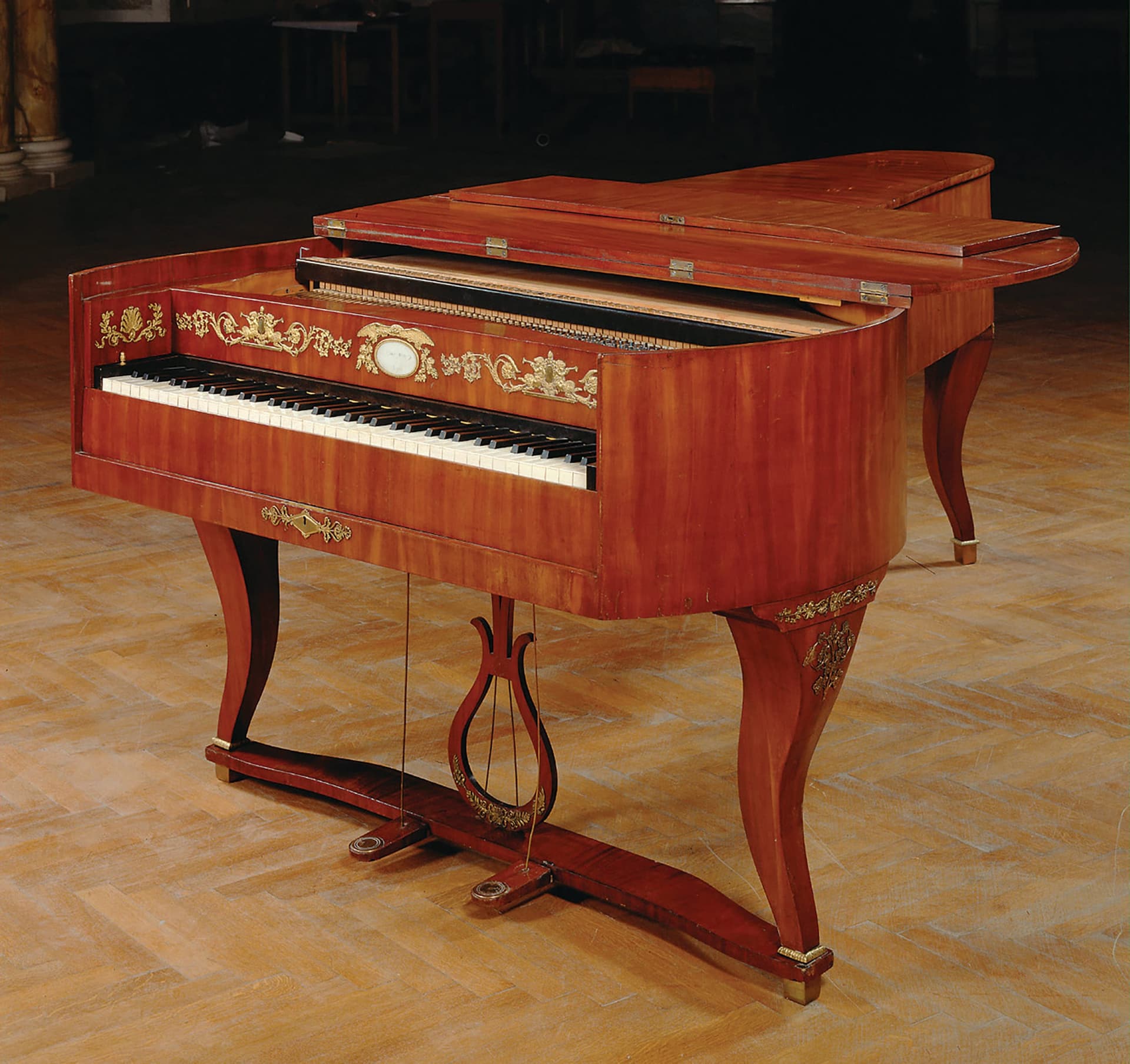 A grand piano sitting on top of a hard wood floor