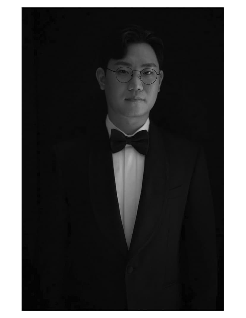 A black and white photo of a man in a tuxedo