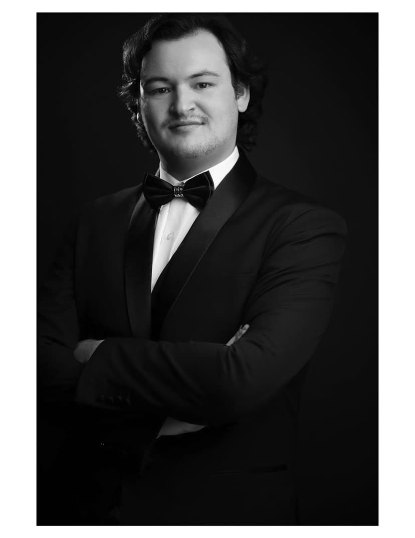 A black and white photo of a man in a tuxedo