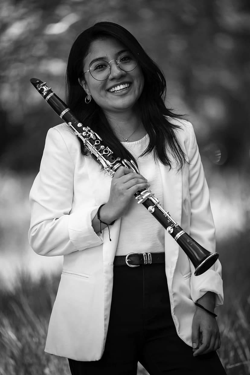 A woman in a suit holding a flute