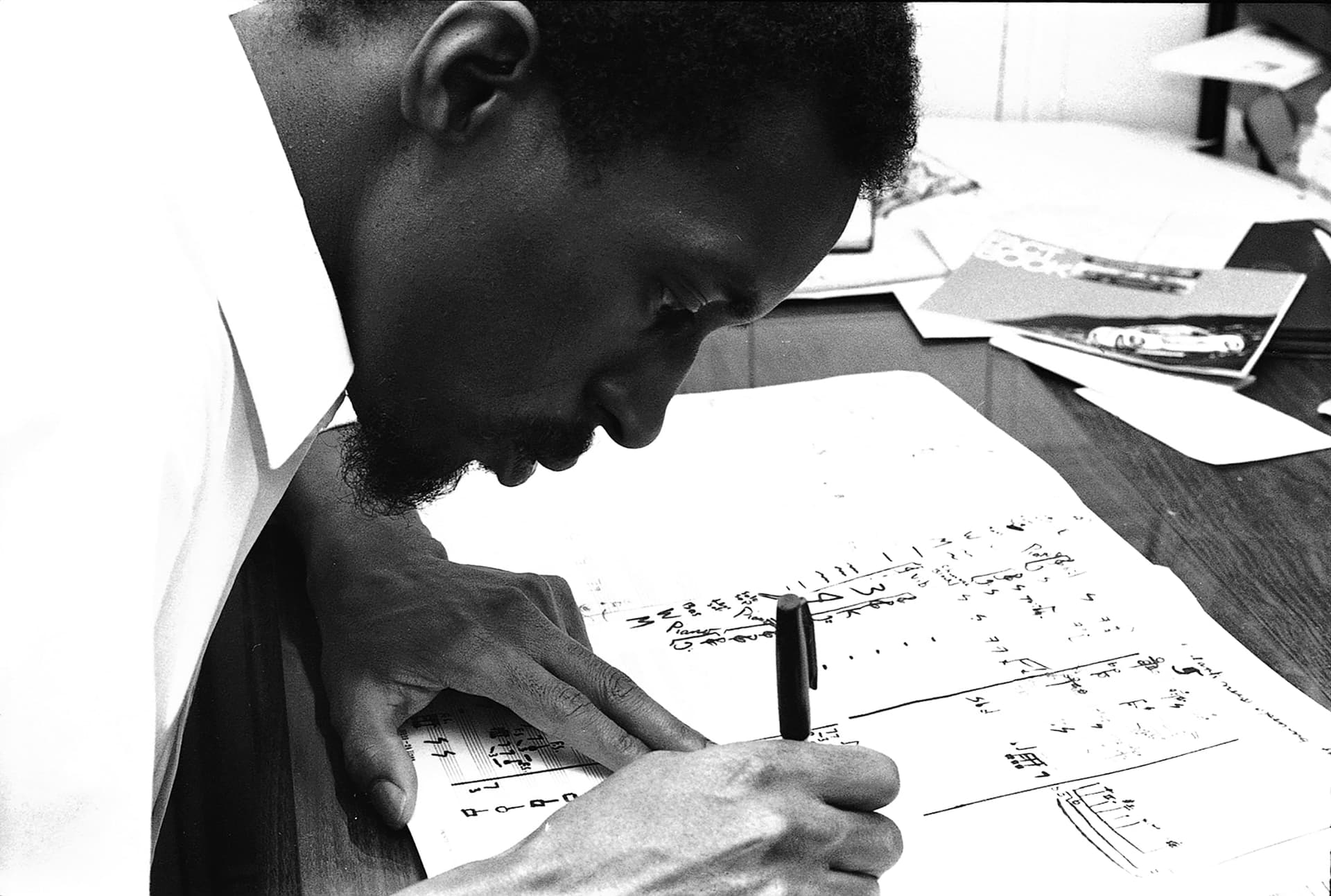 A man writing on a piece of paper with a pen