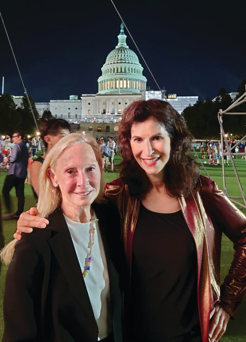 Two women standing next to each other in front of a building