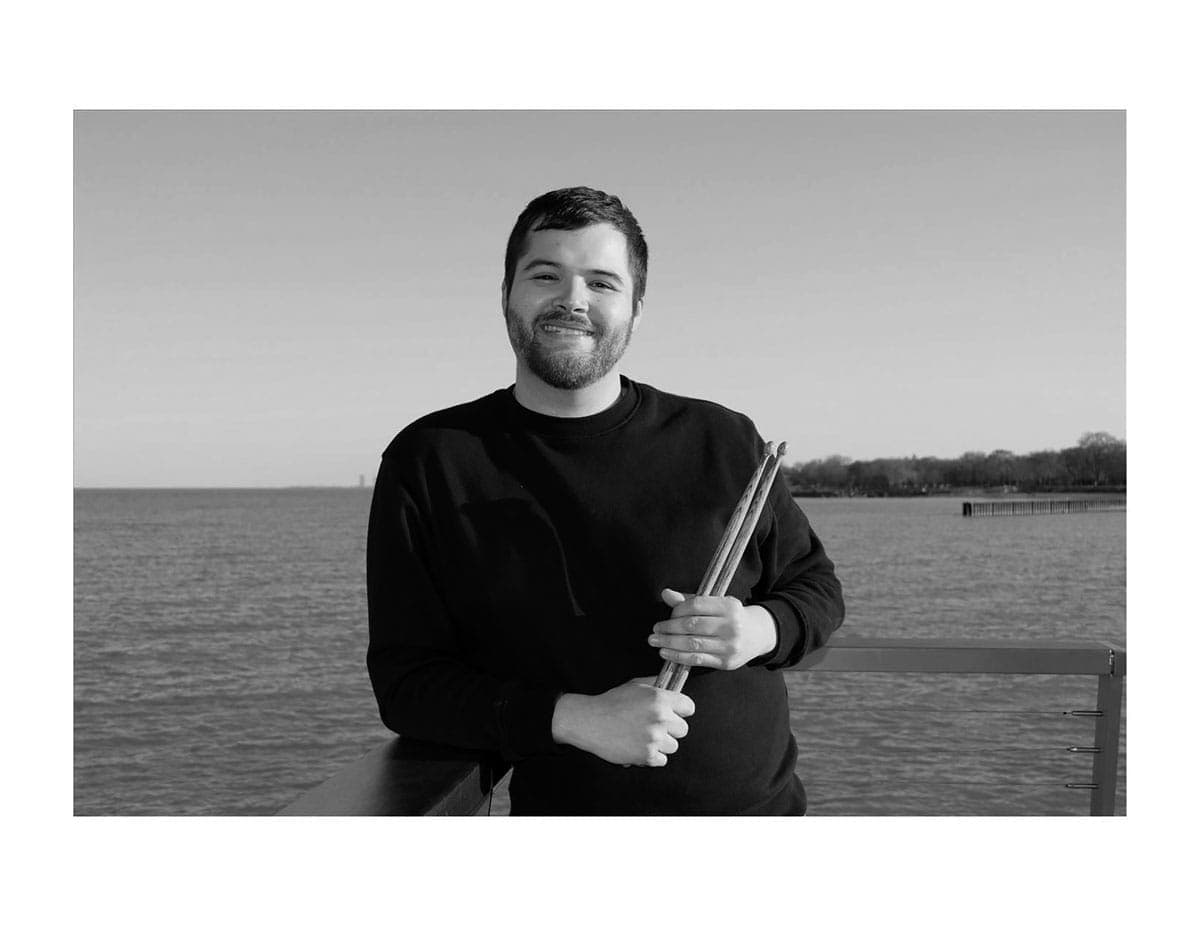 A man is holding a sword by the water