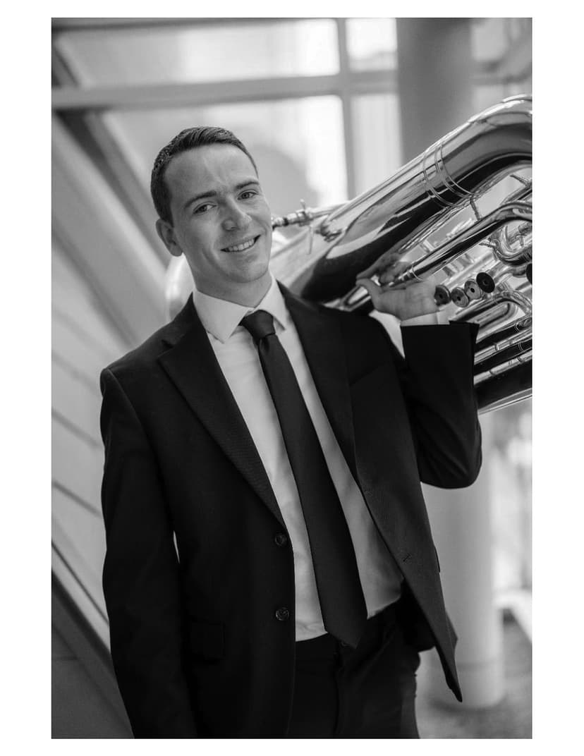 A man in a suit and tie holding a trumpet