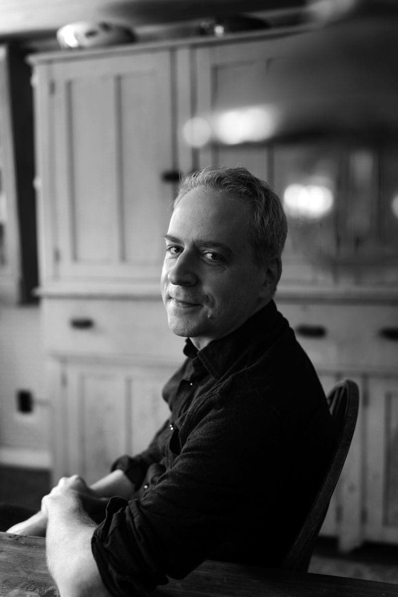 A black and white photo of a man sitting at a table