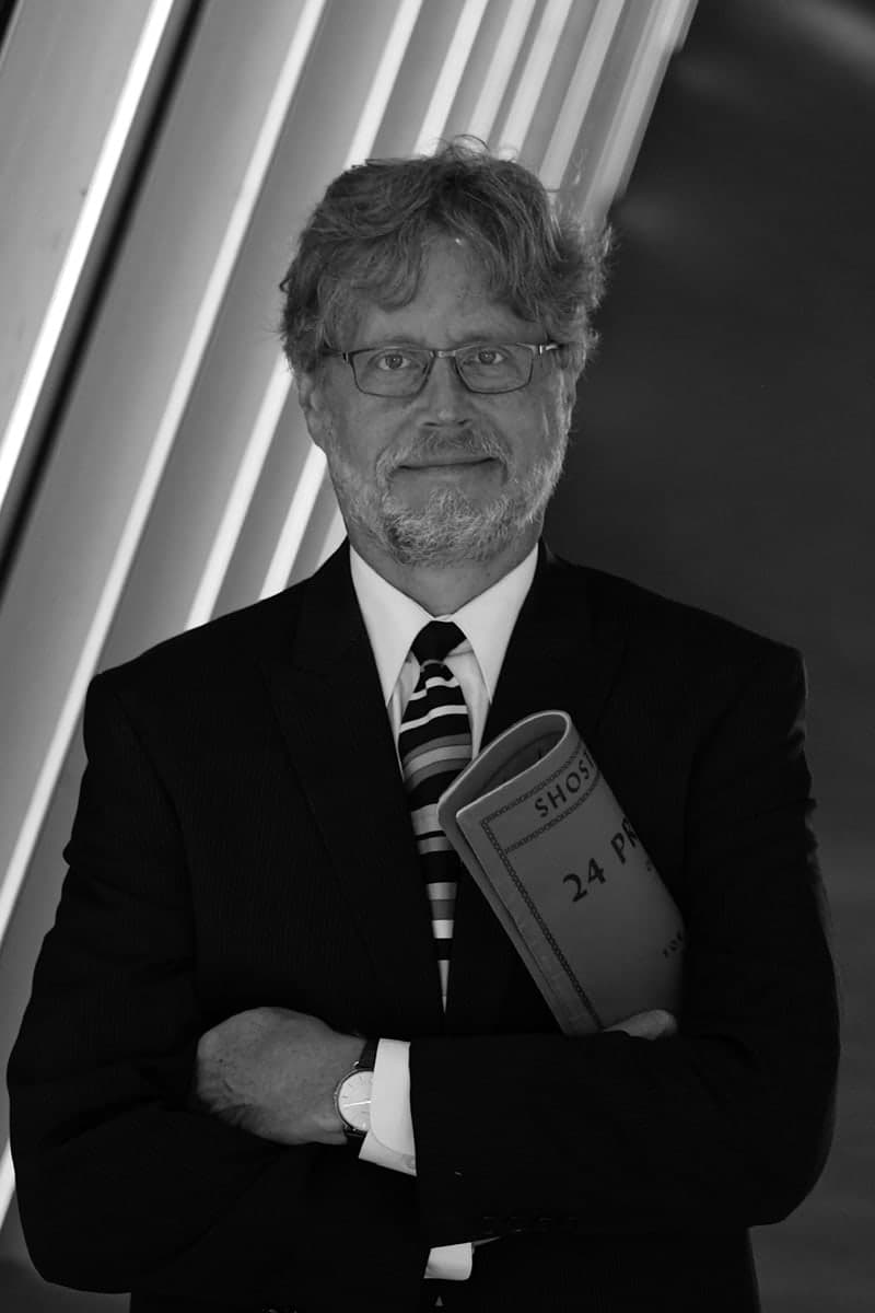 A man in a suit and tie holding a book