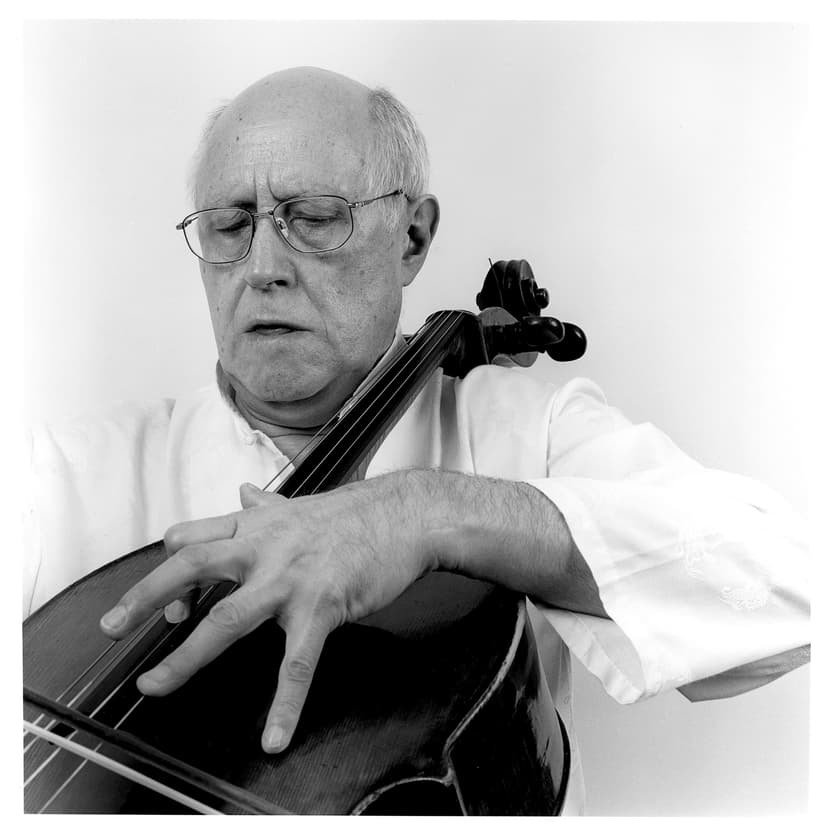 A man with glasses playing a cello