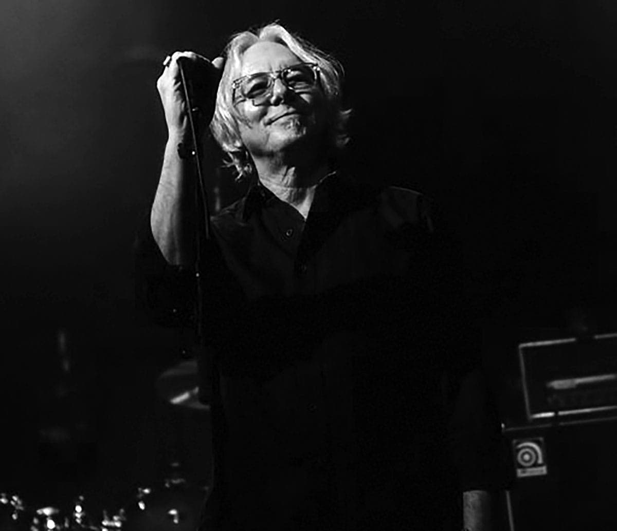 A black and white photo of a man holding a microphone