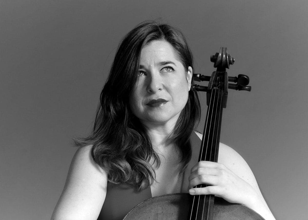 A woman holding a violin in her right hand