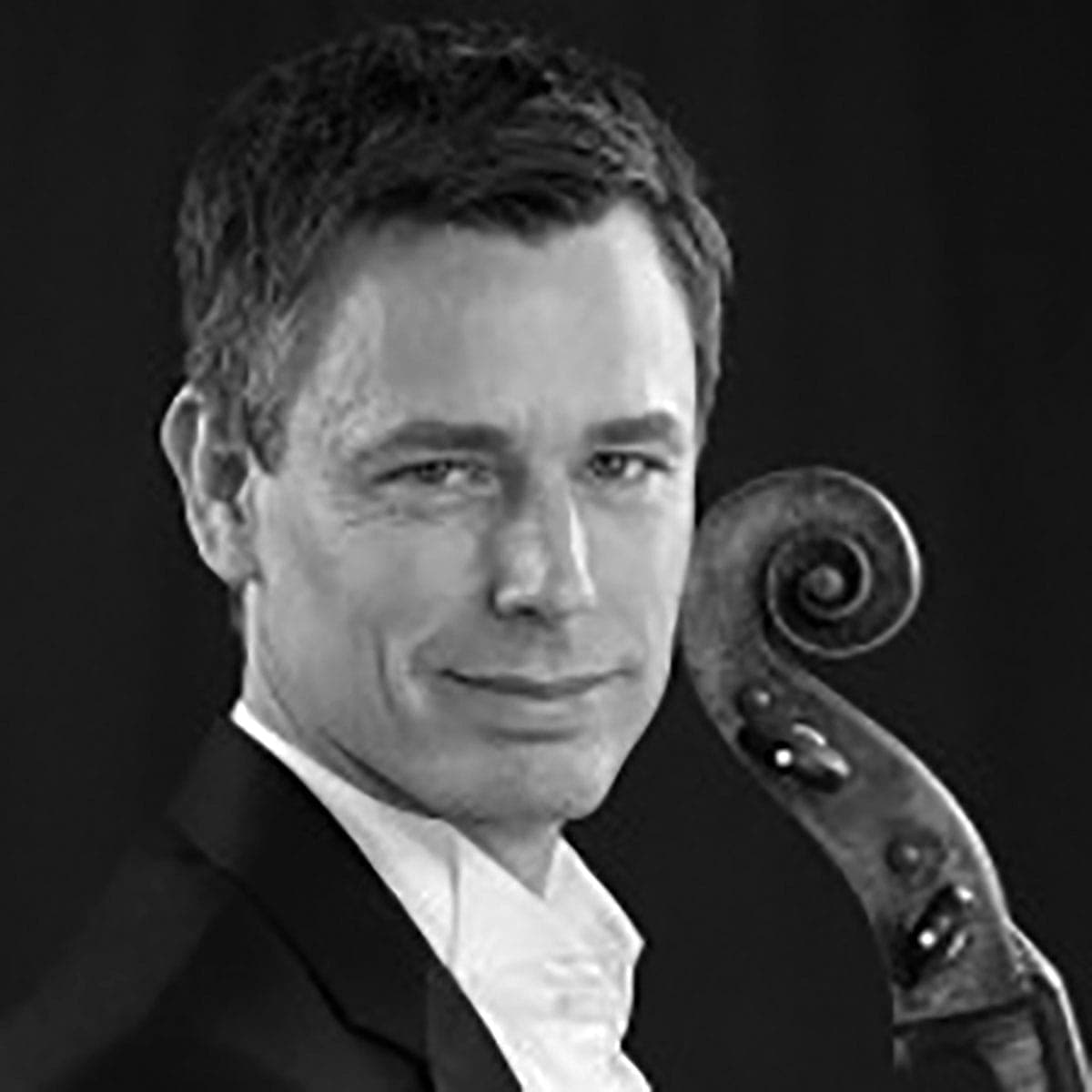 A man in a tuxedo holding a violin