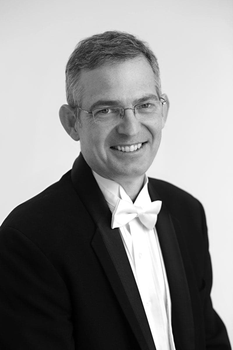 A black and white photo of a man in a tuxedo